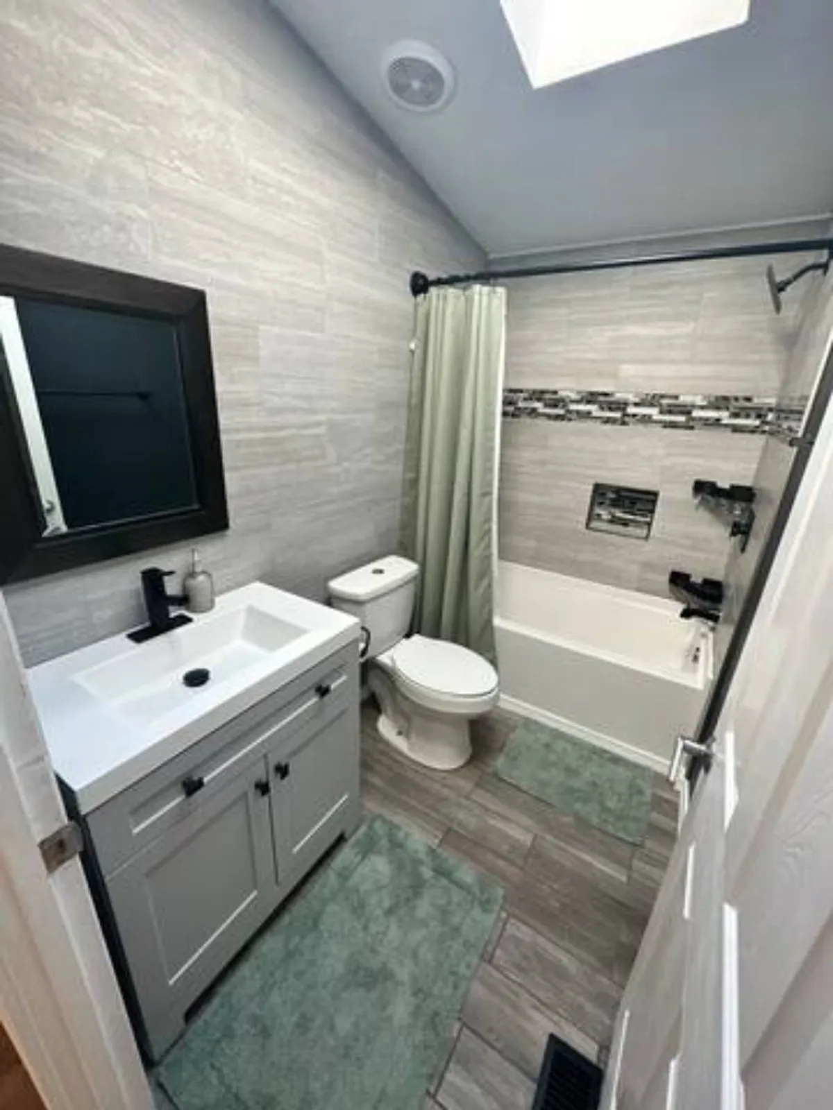 A serene bathroom with a well-lit vanity, walk-in shower, and soft curtains, offering a tranquil spot for unwinding after a day of exploration. The setting is peaceful, emphasizing comfort and privacy.
